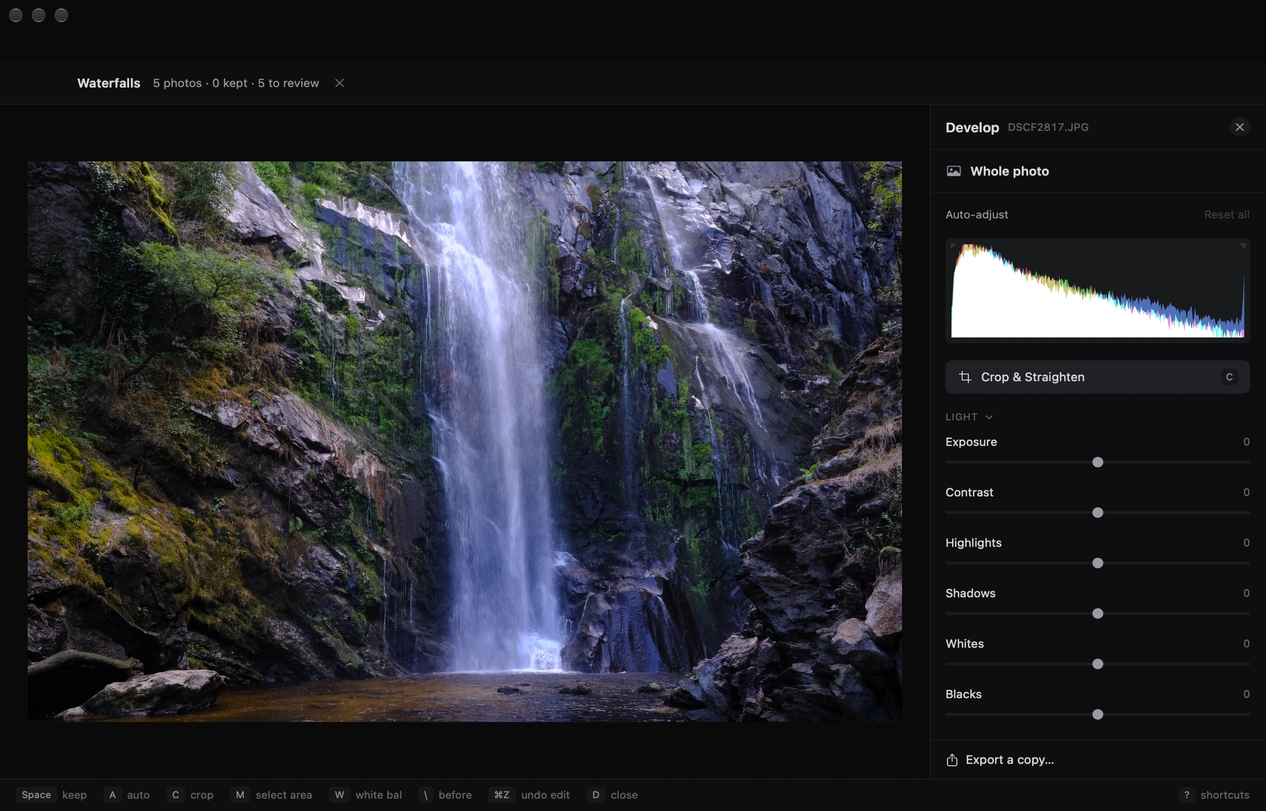 Fovea’s Develop view: exposure, light and color adjustments, a histogram, and crop controls beside the waterfall photograph.
